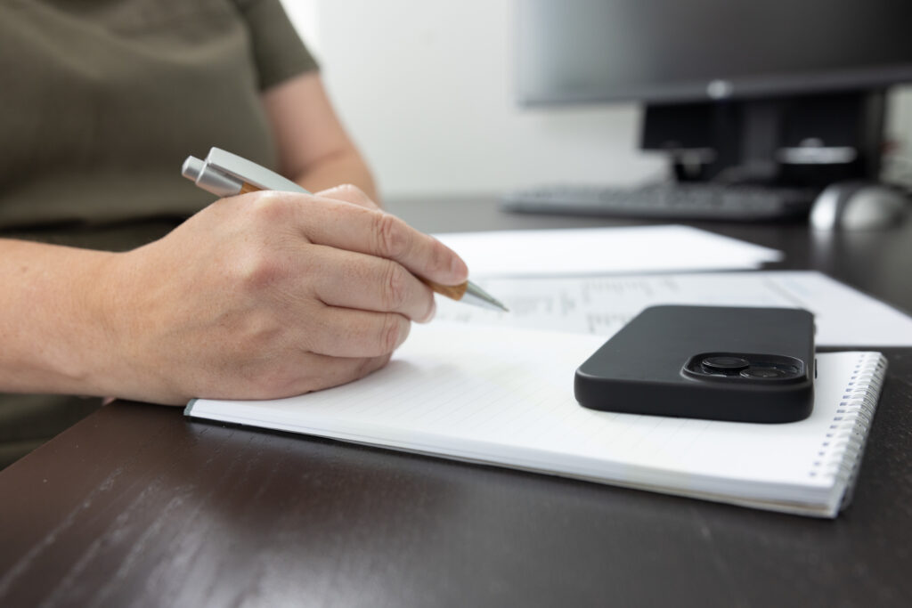 Coach Kim van den Broek zit met papier en pen